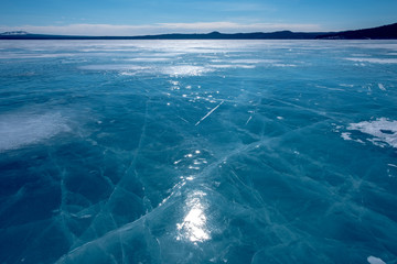 Fototapeta na wymiar Cracks on ice. Frozen lake.