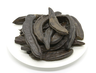 a plate full of carob on isolated white surface