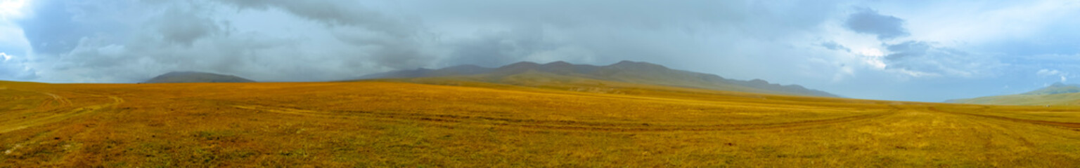 Obraz premium Scenic mountain valley landscape with rain clouds background. Nature background. Rural scenery. Dramatic scene. Autumn background. Mountain valley. Assy plateau in Kazakhstan.