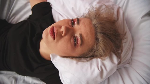 Unhappy Girl sings and suffers in bed. Shooting a clip.