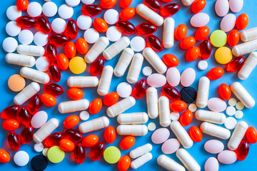 Different colorful many pills in abstract style. Healthy background. Health care, medical concept. Blue background.