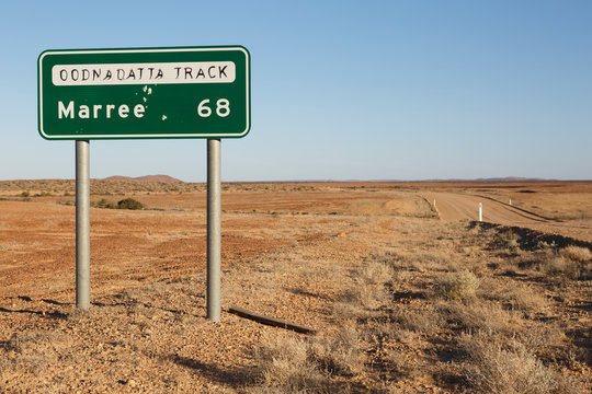 Marree Oodnadatta Track signage selective focus, with bullet holes in sign metal, located roadside of a dirt highway in the outback of Australia on a summers day, Marree, South Australia