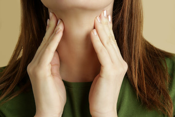 Portrait of sick caucasian woman with sore throat, cold, flu or thyroid gland problem