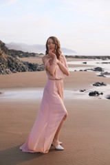 Fototapeta na wymiar Girl with a tattoo on the beach, femininity, a walk on the beach at sunset. Vertical shot, Oregon USA, Cannon Beach