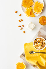 Vegetarian breakfast with granola and fruits on white background top-down frame copy space