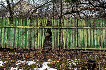 An old fence in the countryside with broken pickets. Selective focus.