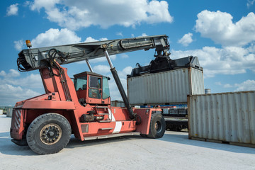 Fototapeta na wymiar Forklift handling container box loading at the Docks with Truck.