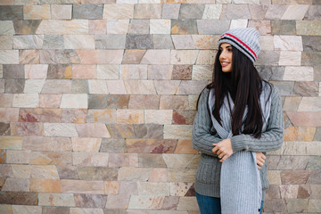 Naklejka premium Winter girl happy and smiling. Lifestyle studio photo isolated portrait of a woman on a gray background.