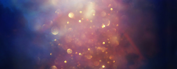 background of abstract glitter lights. gold, blue and black. de focused