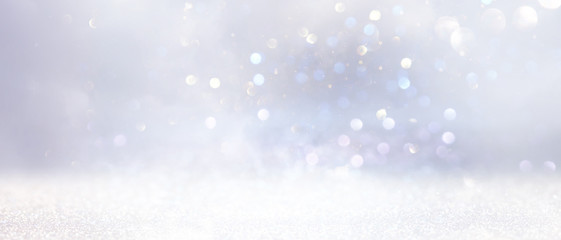 glitter vintage lights background. gold, silver and white. de-focused