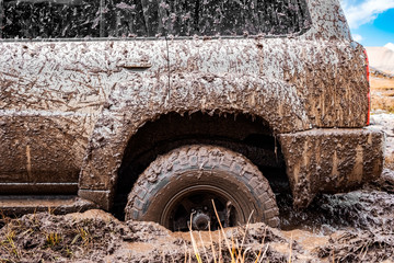 Adventure travel concept background. 4x4 off-road suv car stuck in mud. Adventure travel concept...