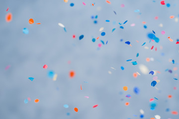 Colorful confetti falling on a holiday on a blue background