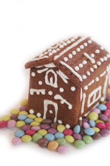 Homemade Christmas chocolate cookies in shape of little house with colorful chocolate candies isolated on white background