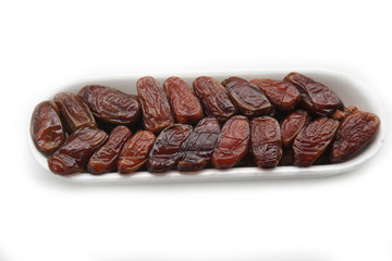 Dried dates ina plastic bowl isolated on white background. Date fruits on white