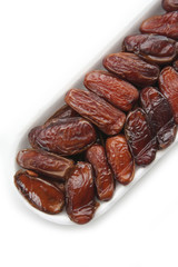 Dried dates ina plastic bowl isolated on white background. Date fruits on white