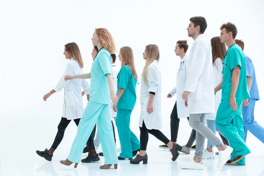 successful young doctor standing in front of her colleagues