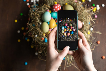 Woman making photo of Easter decorations on phone