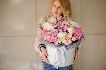 Beautiful large bouquet of pink flowers in a round box decorated with ribbons