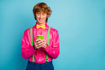 Portrait of positive cheerful guy use smartphone have online social media communication wear good look bow tie isolated over bright blue color background