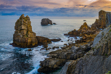 Incredible cliffs on the coast near the village of Liencres before sunrise. Cantabria. Northern coast of Spain