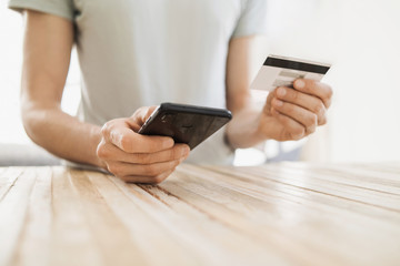 Man hands holding credit card and using smart phone, travel, online shopping, ecommerce, internet banking, finance and freelance concept