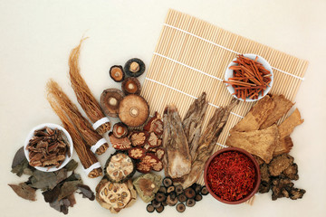 Chinese herb and spice collection  used in traditional herbal medicine on bamboo mat and mottled...