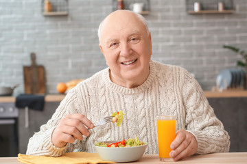 Portrait of elderly man having lunch at home