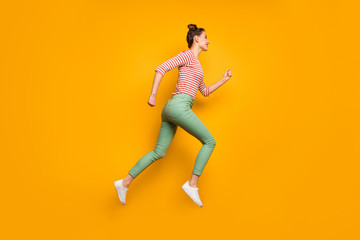 Full body profile photo of attractive pretty lady jumping high up rushing low prices shopping wear red white pullover shirt green pants footwear isolated bright yellow background
