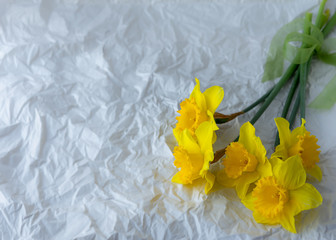 Flowers on grey background. Spring white narcissus with yellow center lying on grey table with plaster texture
