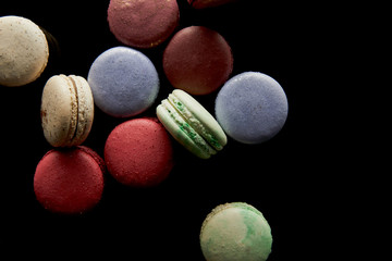 top view of assorted delicious colorful french macaroons isolated on black