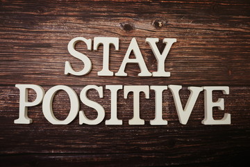 Stay Positive alphabet letter on wooden background