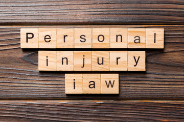 personal injury law word written on wood block. personal injury law text on table, concept