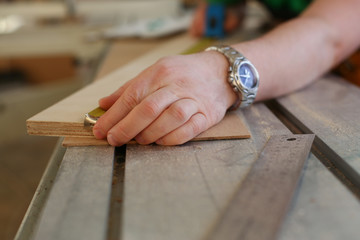 Arms of worker measuring wooden bar closeup. Manual job, DIY inspiration improvement job fix shop...