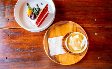 Cup of coffee and strawberry cake on the wooden table. Image of top view.