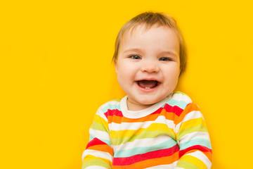Laughing child baby  on yellow background