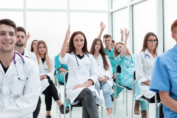 top view. a group of smiling doctors pointing at you.