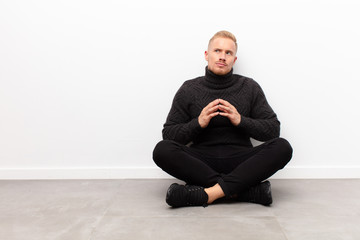 young blonde man scheming and conspiring, thinking devious tricks and cheats, cunning and betraying...