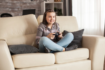Focused little girl with braces playing video games