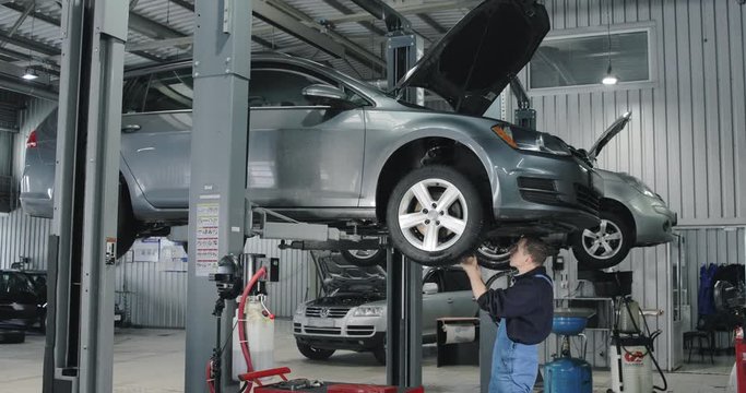 Mechanic Repairing Car On The Lift