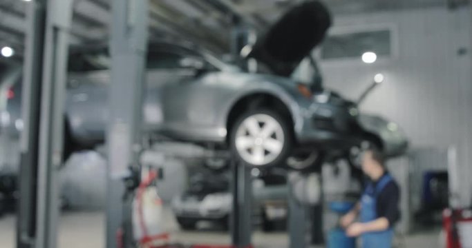 Blurred Background. Auto Mechanic Working On Car. Dealer Service Center