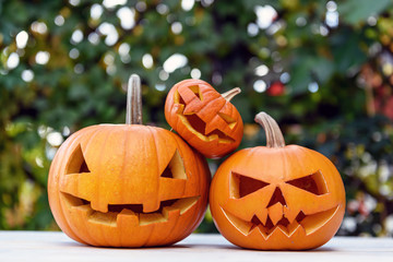 Three Halloween pumpkins or jack-o-lantern at home terrace. Decoration and holidays concept