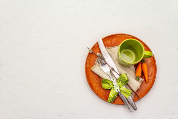 Easter table setting on textured white putty background. Spring holiday card template. Cutlery,...