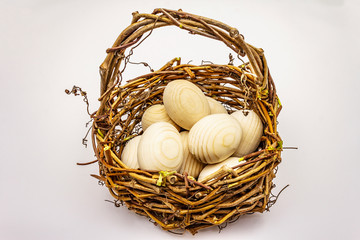 Easter wicker basket isolated on white background. Zero waste, DIY concept. Wooden eggs