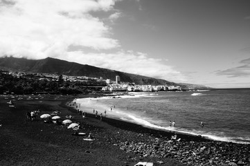 picturesque Playa Jardín beach on the Spanish Canary Island Tenerife with black volcanic sand blue...