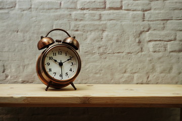 vintage alarm clock with space copy on wooden shelves background