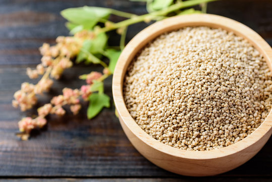 Organic raw brown quinoa seed (Chenopodium quinoa) in a bowl on wooden background, healthy food