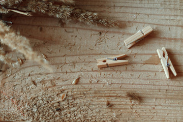  A wooden table on which lie cute little clothespins and a bouquet of dried flowers. View from...