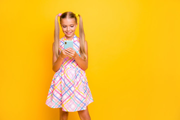 Photo of beautiful small lady hold telephone young influencer write new post for own popular modern blog wear checkered sun dress isolated bright yellow color background