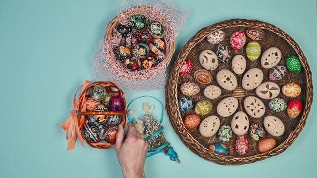 Hands holding basket with easter eggs near basket on blue background. Easter is holy. 4k