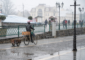 Naklejka premium Cyclist on the city roadway on a rainy day in motion blur